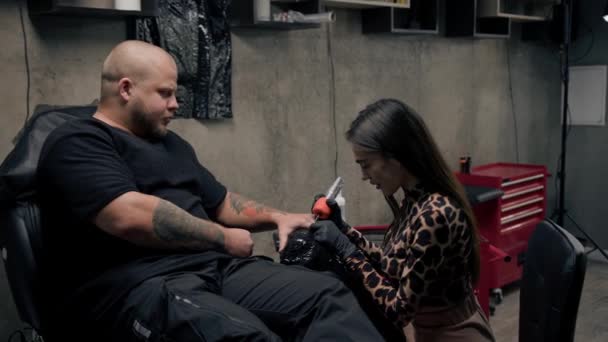 Vrouw Tattoo Artiest Maakt Tatoeage Naar Een Man Zijn Arm — Stockvideo