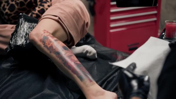 Artista Del Tatuaje Masculino Tira Tatuaje Con Una Película Cliente — Vídeo de stock