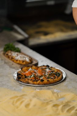 Profesyonel mutfak - şef lezzetli pizza hazırlıyor, pizza pişirme süreci
