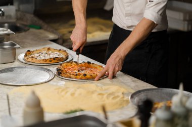 Profesyonel mutfak - şef lezzetli pizza hazırlıyor, pizza pişirme süreci