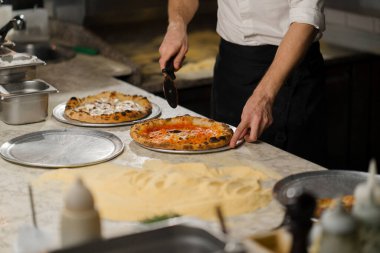 Profesyonel mutfak - şef lezzetli pizza hazırlıyor, pizza pişirme süreci