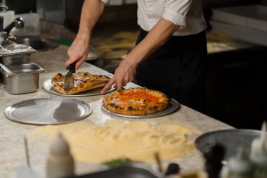 Profesyonel mutfak - şef lezzetli pizza hazırlıyor, pizza pişirme süreci