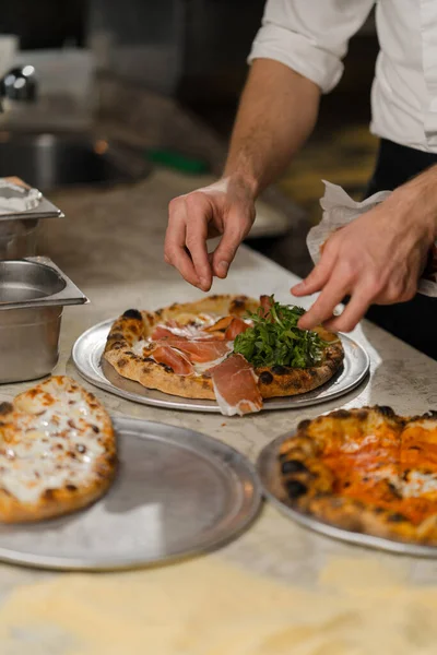 Profesyonel mutfak - şef lezzetli pizza hazırlıyor, pizza pişirme süreci