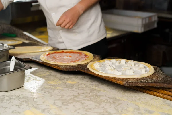 Restoranda, profesyonel bir şef pizza hazırlar, hamura sos ekler. Lezzetli organik yiyecekler pişirmek. Yavaş çekim