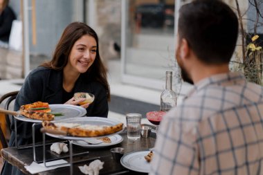 Randevu - Erkek ve kadın restoranın terasında oturuyorlar, pizza, kokteyl