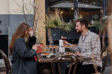 Randevu - Erkek ve kadın restoranın terasında oturuyorlar, pizza, kokteyl