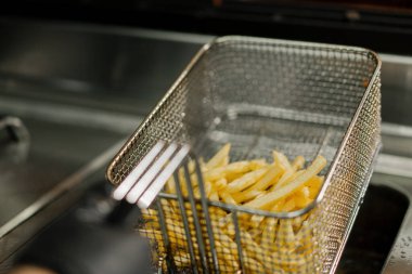 Yakın çekim. Profesyonel bir restoranın mutfağında patates kızartması pişirme işlemi.