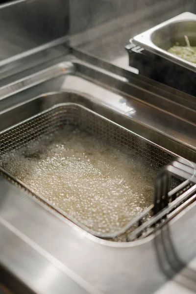 Close-up - process of cooking french fries in a professional kitchen of a restaurant