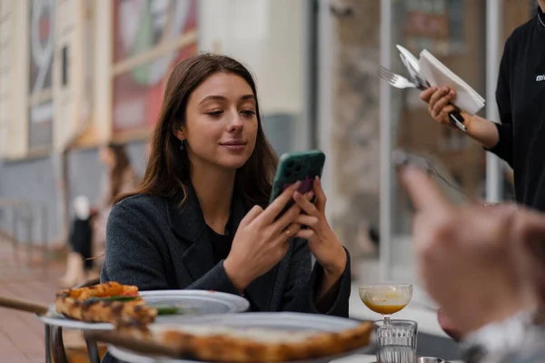レストランに座って スマートフォンでテキストメッセージ ボーイフレンド 日付の携帯電話の閲覧のガールフレンド — ストック写真