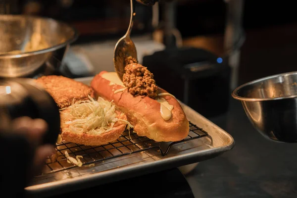 クローズアップ レストランのプロのキッチンでおいしいホットドッグを準備するプロセス — ストック写真