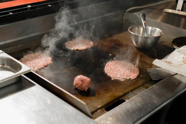 レストランのキッチンのシェフがハンバーガー用のカツレツを作ります スマッシュバーガーステーキ — ストック写真