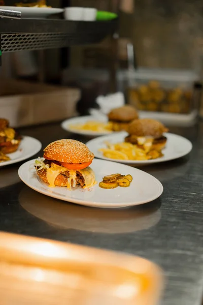 クローズアップ レストランで回転テーブルの上にフライドポテトとハンバーガー 背景にぼやけて働くレストラン — ストック写真