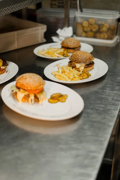 クローズアップ レストランで回転テーブルの上にフライドポテトとハンバーガー 背景にぼやけて働くレストラン — ストック写真