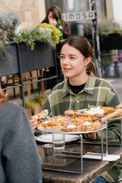 テラス レストランでお友達と会う 女性の女の子はおいしいピザを食べる — ストック写真