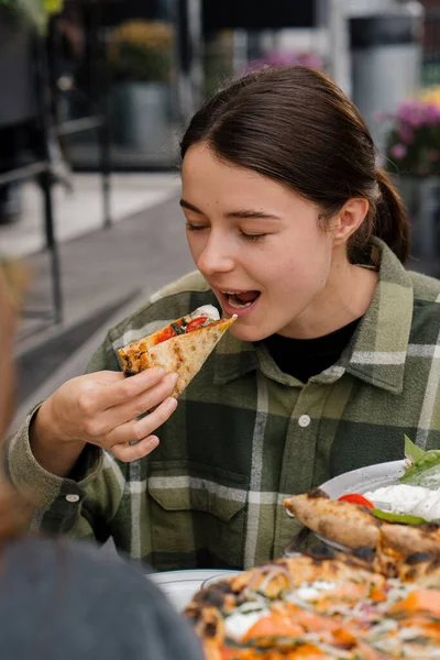 テラス レストランでお友達と会う 女性の女の子はおいしいピザを食べる — ストック写真