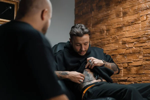 Interior Estúdio Tatuagem Homem Mostra Suas Tatuagens Mestre Tatuador — Fotografia de Stock