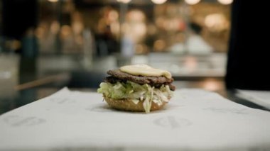 Yakın plan - Şef restoranda hamburger pişiriyor. Burger Bar