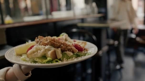 Close Garçonete Carrega Sua Mão Uma Salada Caesar Com Frango — Vídeo de Stock