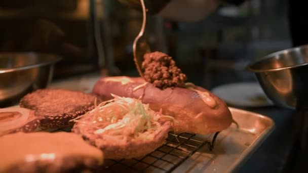 クローズアップ レストランのプロのキッチンでおいしいホットドッグを準備するプロセス — ストック動画