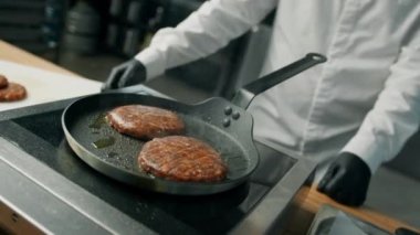 Profesyonel mutfak: şef hamburger için köfte kızartıyor.