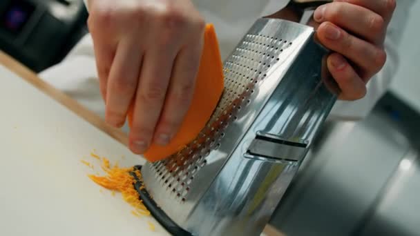Professionelle Küche Küchenchef Reibt Cheddar Käse Auf Feiner Reibe — Stockvideo