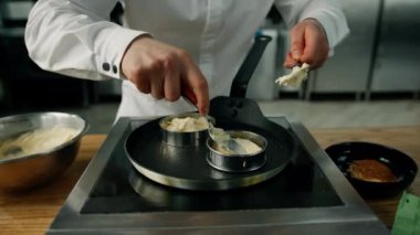 Profesyonel mutfak. Mangırı tavaya koyma süreci. Mutfakta yemek pişirmek için profesyonel aletler.