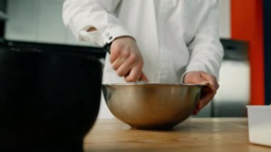 Profesyonel bir mutfakta krep karışımını yemek kabına karıştırmaya yakın. Bir restoranda yemek pişirmek..