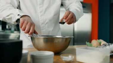 Bir aşçı profesyonel bir mutfakta krep karışımına soya sosu ekler. Krep yapma süreci.