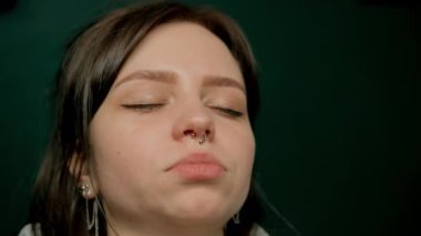 Piercing ustası kıza piercing yaptırıyor, burun delici.