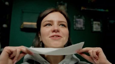 Piercing ustası kıza piercing yaptırıyor, burun delici.