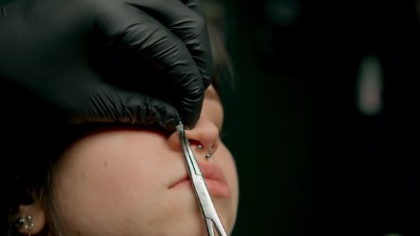 穿孔大师使穿孔女孩 隔鼻孔穿孔 — 图库视频影像