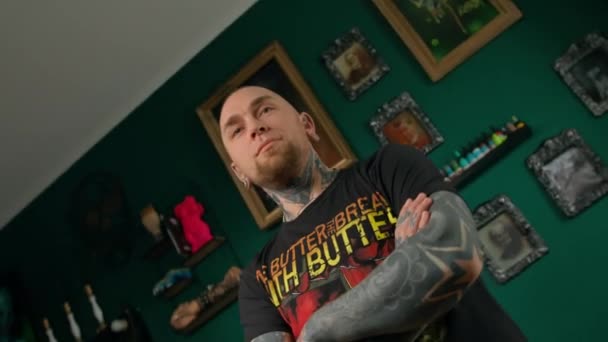 Een Man Met Tatoeages Piercings Kijkt Naar Camera Tattoo Studio — Stockvideo