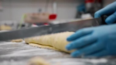 Fırındaki mutfak - tarçın yapma işlemi, kadın fırıncı hamuru kesiyor.