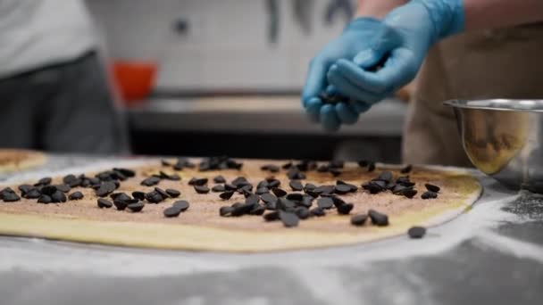パン屋のキッチン シナモンを作るプロセス 女性のパン屋はベーキングに顆粒でチョコレートを使用します — ストック動画