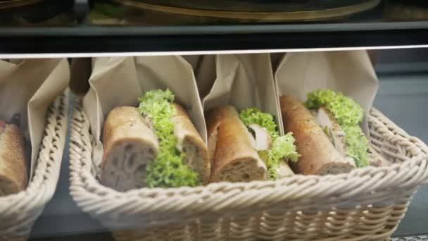 Gyönyörű Ízletes Szendvicseket Raknak Egy Kosárba Egy Bolti Polcon Pékségben — Stock videók