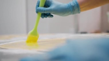 Fırındaki mutfak... Cinnabon pişirme işlemi, kadın fırıncı yumurta sarısı kullanır.