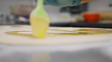 Fırındaki mutfak... Cinnabon pişirme işlemi, kadın fırıncı yumurta sarısı kullanır.