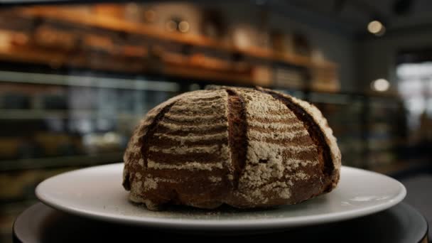 Крупный План Пекарня Свежеиспеченный Темный Хлеб Вращающейся Поверхности — стоковое видео