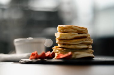 Kahvaltı için masasında çilek olan krep yığınının görüntülerini kapat.