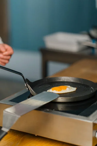 Aşçı Restoranda Kahvaltıda Spatulayla Kızartma Tavasından Kızarmış Yumurta Alır — Stok fotoğraf