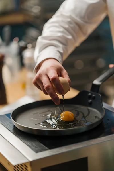 鍋に卵を破る料理人プロのキッチンで朝食を準備 — ストック写真