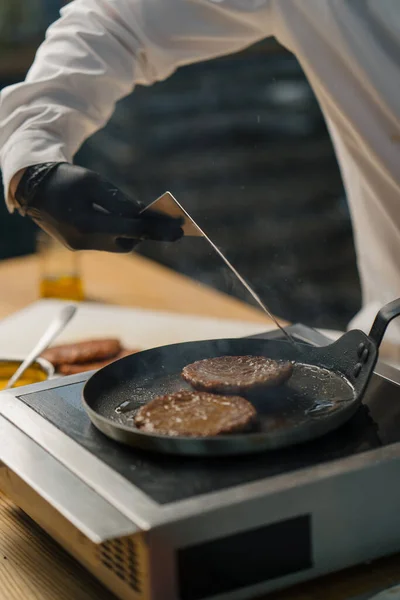 Kuchař Černých Rukavicích Převrátí Lahodné Hamburgerové Placičky Pánvi Obracečem Profesionální — Stock fotografie