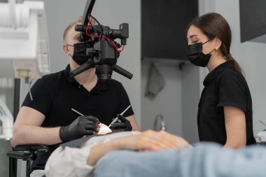 Diş hekimliği bir hastayı mikroskopla muayene eder.