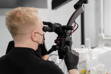 Diş hekimliği bir hastayı mikroskopla muayene eder.