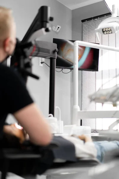 牙科医生在屏幕上看病人的牙齿 — 图库照片