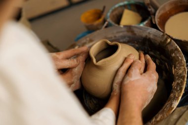 Çömlekçilik atölyesi çömlekçiye çömlek çifti heykeli yapmayı öğretiyor.