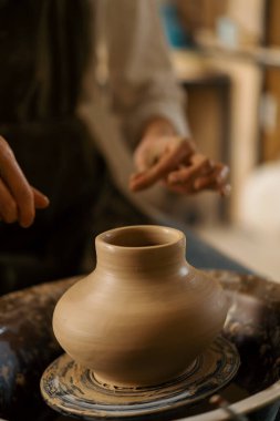 Çömlekçilik atölyesi çömlekçiye çömlek çifti heykeli yapmayı öğretiyor.