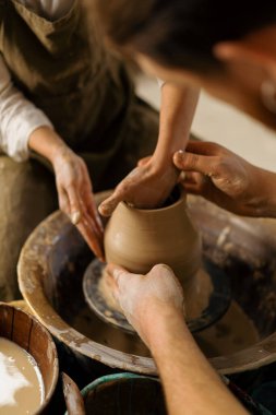 Çömlekçilik atölyesi çömlekçiye çömlek çifti heykeli yapmayı öğretiyor.