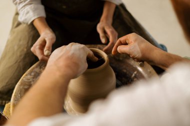 Çömlekçilik atölyesi çömlekçiye çömlek çifti heykeli yapmayı öğretiyor.