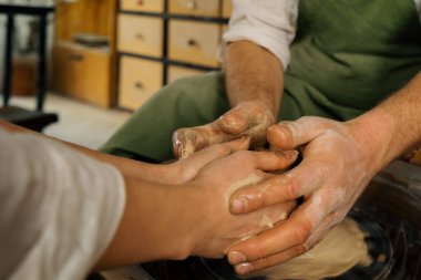 Çömlek atölyesi çömlekçisi çömlekçiden yapılmış çömlekçi tekerleği ürünü ile ana sınıfı yönetir.